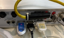 Back-view of timing computer with serial port connected to laptop.